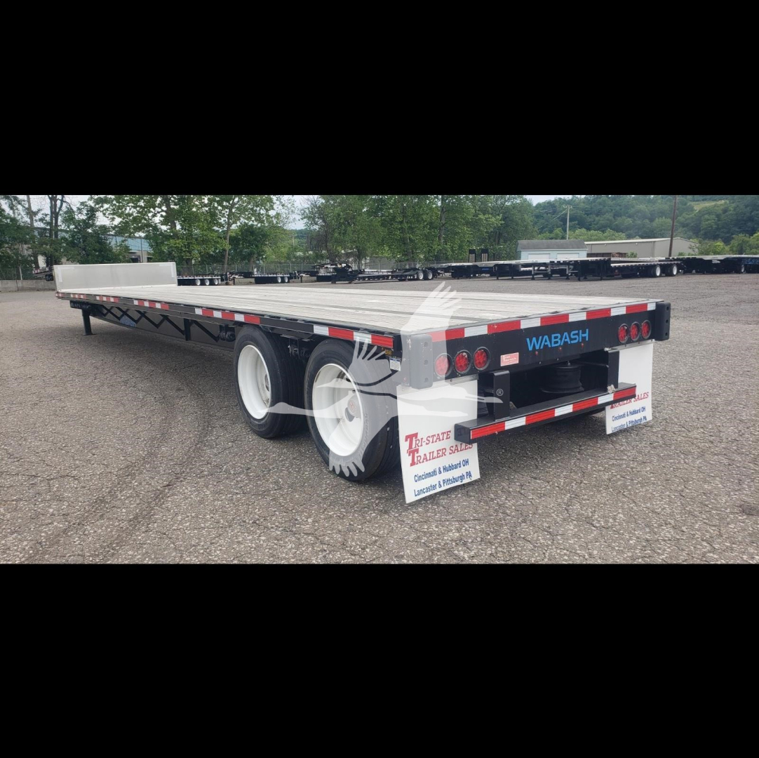Wabash steel drop trailer with dual rear axles, showing brand name WABASH on tailgate, reflective striping, and mud flaps. Back shows lights, license plate area. Side is flatbed deck.