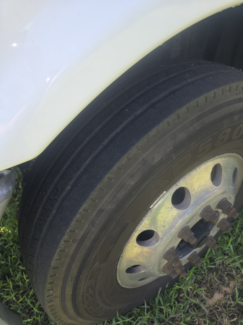 Front wheel of a Freightliner Cascadia CA125DC day cab truck showing tire and wheel with hub.