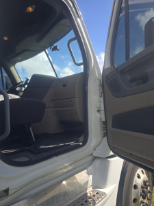 Truck cab interior of a 2017 Freightliner Cascadia CA125DC showing open door, driver's seat, and cabin entry with steps.