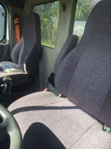 Cab interior of a Freightliner Cascadia CA125DC showing front bucket seats and driver area.