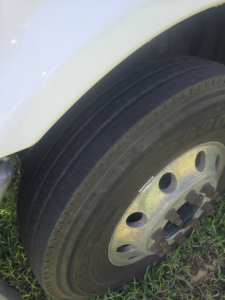 Front wheel of a Freightliner Cascadia CA125DC day cab truck showing tire and wheel with hub.