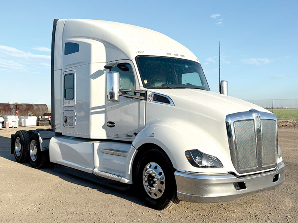 Kenworth T680 tractor in white showing aerodynamic sleeper cab, front chrome grille, dual rear axles, side exhausts. VIN tag not legible, no model labels visible.