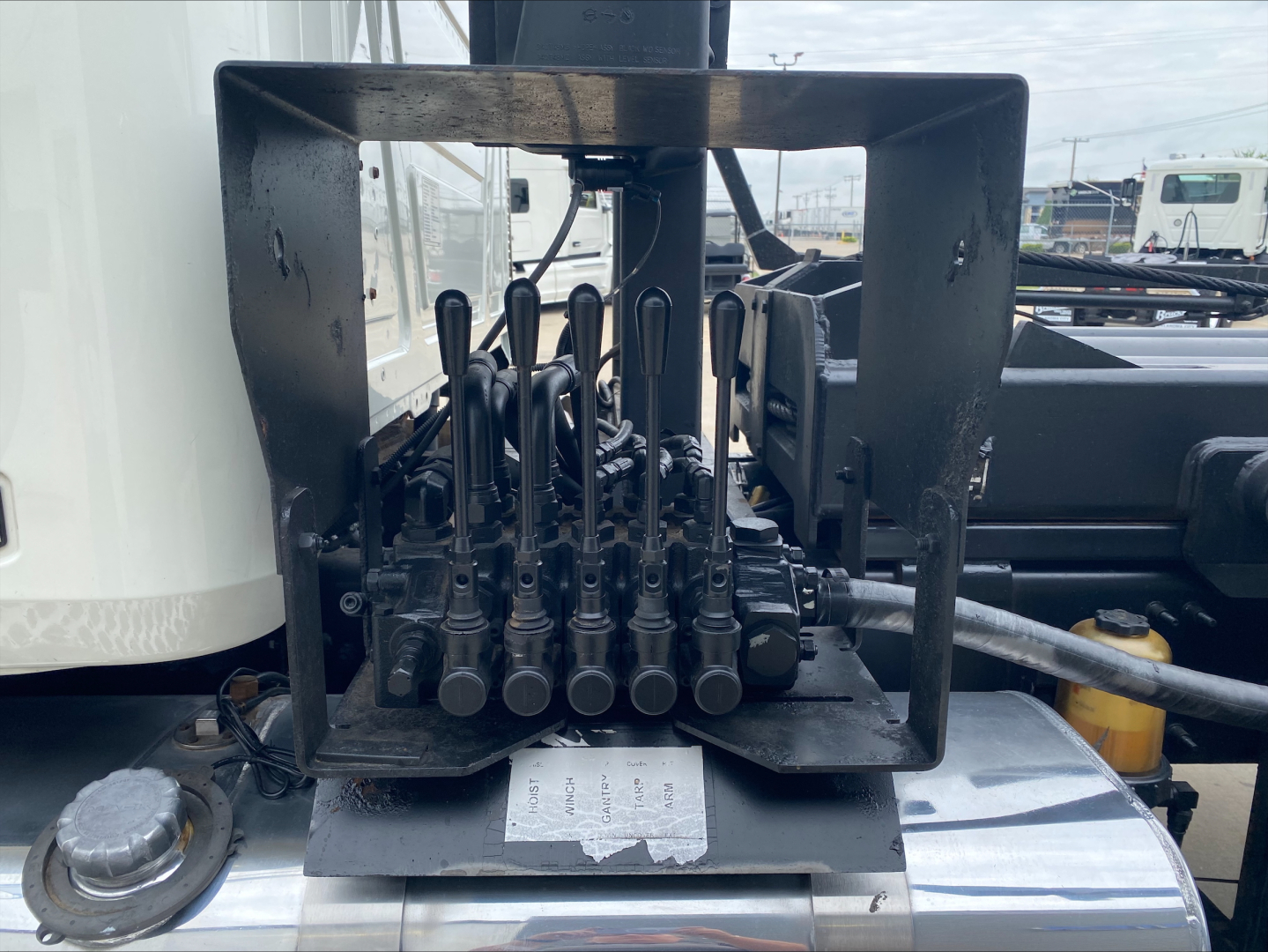 Trucks engine bay component rack with multiple hydraulic levers and control rods in a rectangular frame, Mack GU533 listing image.