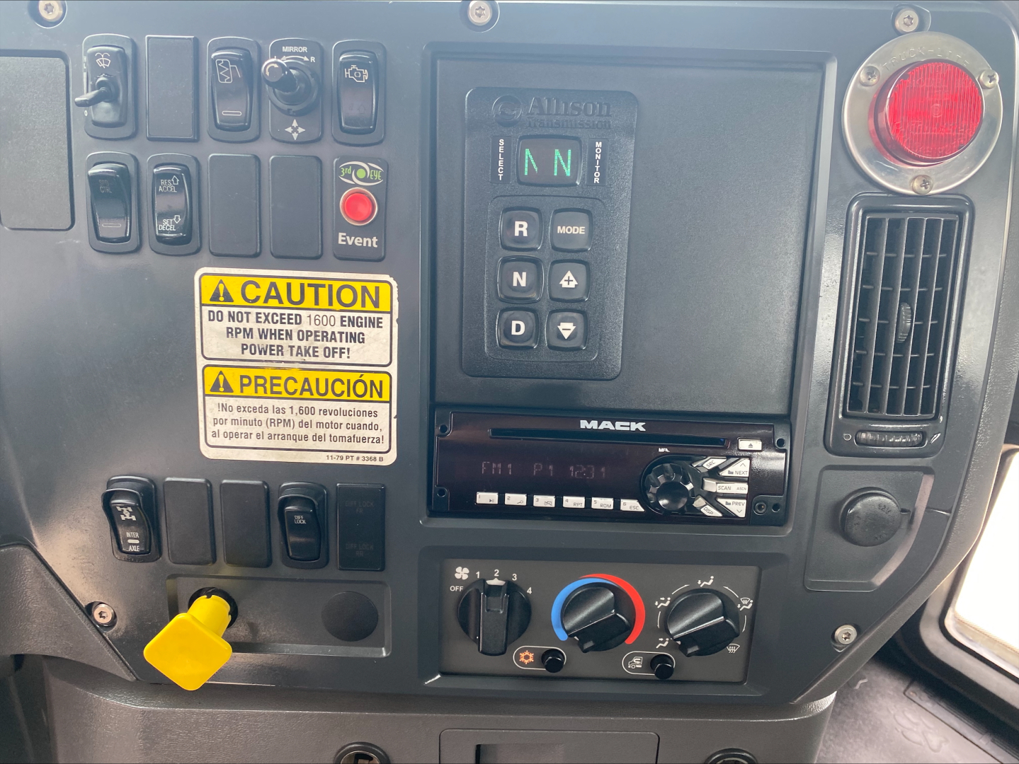 Mack GU533 dashboard showing control switches, gear selector with N R D, warning labels, climate controls, and radio display.