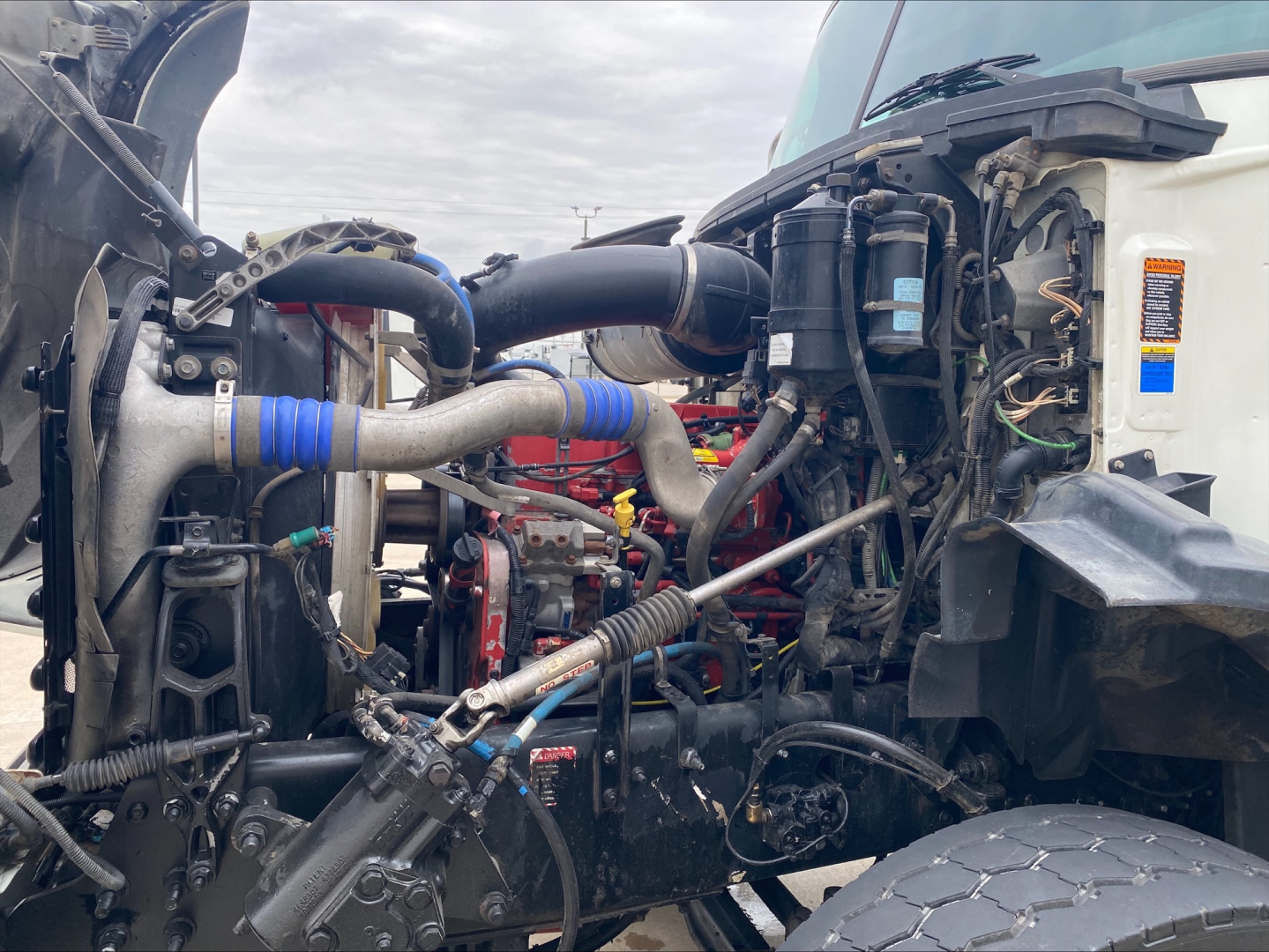 Mack GU533 engine bay showing various hoses, wiring, and components under the hood.