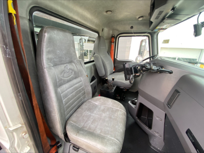 Truck cab interior of a 2018 Mack GU533 showing driver's seat, passenger seat, dashboard, steering wheel, and control panels.