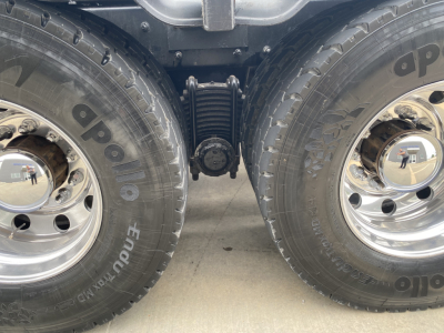 Mack GU533 rear wheel area showing dual rear tires, central suspension linkage, chrome wheels, and tire sidewalls with brand lettering.