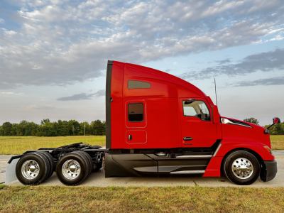 Kenworth T680 tractor in red side profile view showing sleeper cab and rear tandem axles.