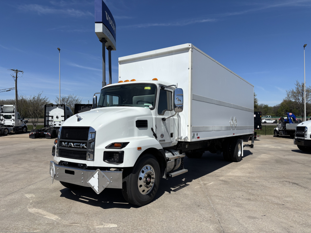 Box truck from a Mack MD7 lineup showing a white cab with a large dry van body and chrome front bumper. Clear blue sky.