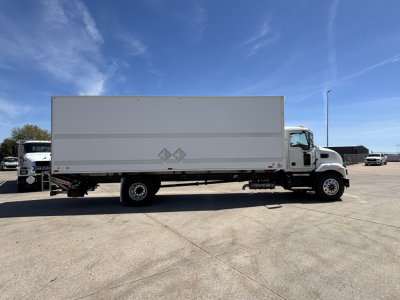 Truck side view of a 2025 Mack MD7 box truck in a dealership lot showing a large white cargo box and cab with clear sky.