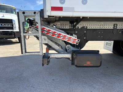 Truck chassis side view showing rear underride guard and hydraulic system under a 2025 Mack MD7 trailer/box truck.