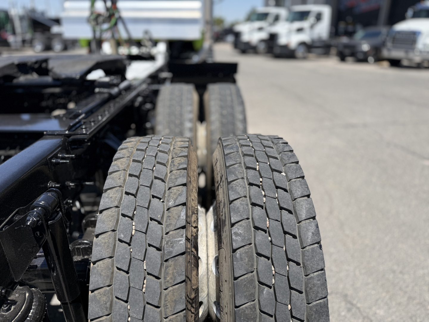 Two rear dual tires on a Mack AN64T truck chassis showing tread pattern and open frame.