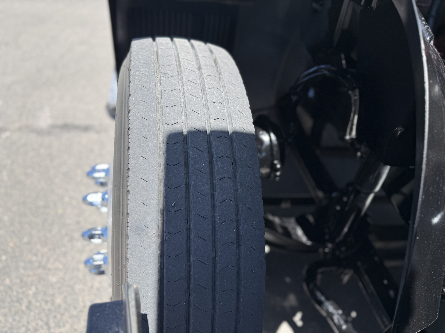 Wheel and side of Mack AN64T conventional daycab showing front tire tread and part of chassis/axle area.