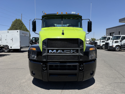 Mack AN64T conventional daycab truck front view. Bright lime green cab with black bumper, large Mack grille, headlights, and side mirrors.