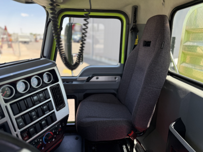 Interior of a Mack AN64T truck cab showing driver seat and dashboard with gauges and radio knobs.