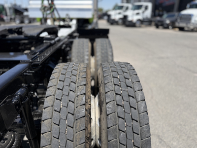 Two rear dual tires on a Mack AN64T truck chassis showing tread pattern and open frame.