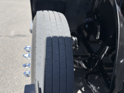 Wheel and side of Mack AN64T conventional daycab showing front tire tread and part of chassis/axle area.