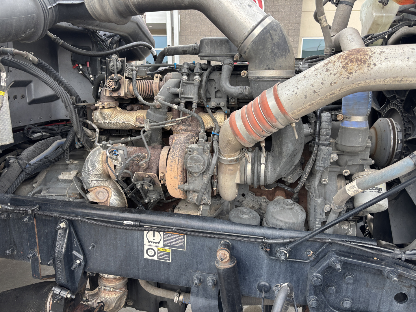 Peterbilt engine bay showing turbocharger hose and engine components in a conventional sleeper truck.