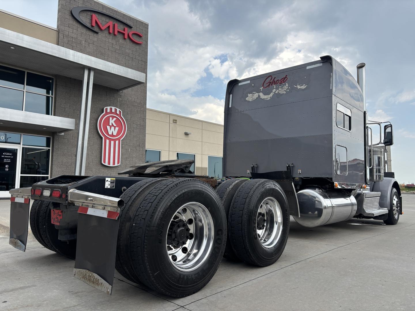 Peterbilt 389 tractor in view showing sleeper cab and dual rear axles with chrome fuel tanks and mud flaps