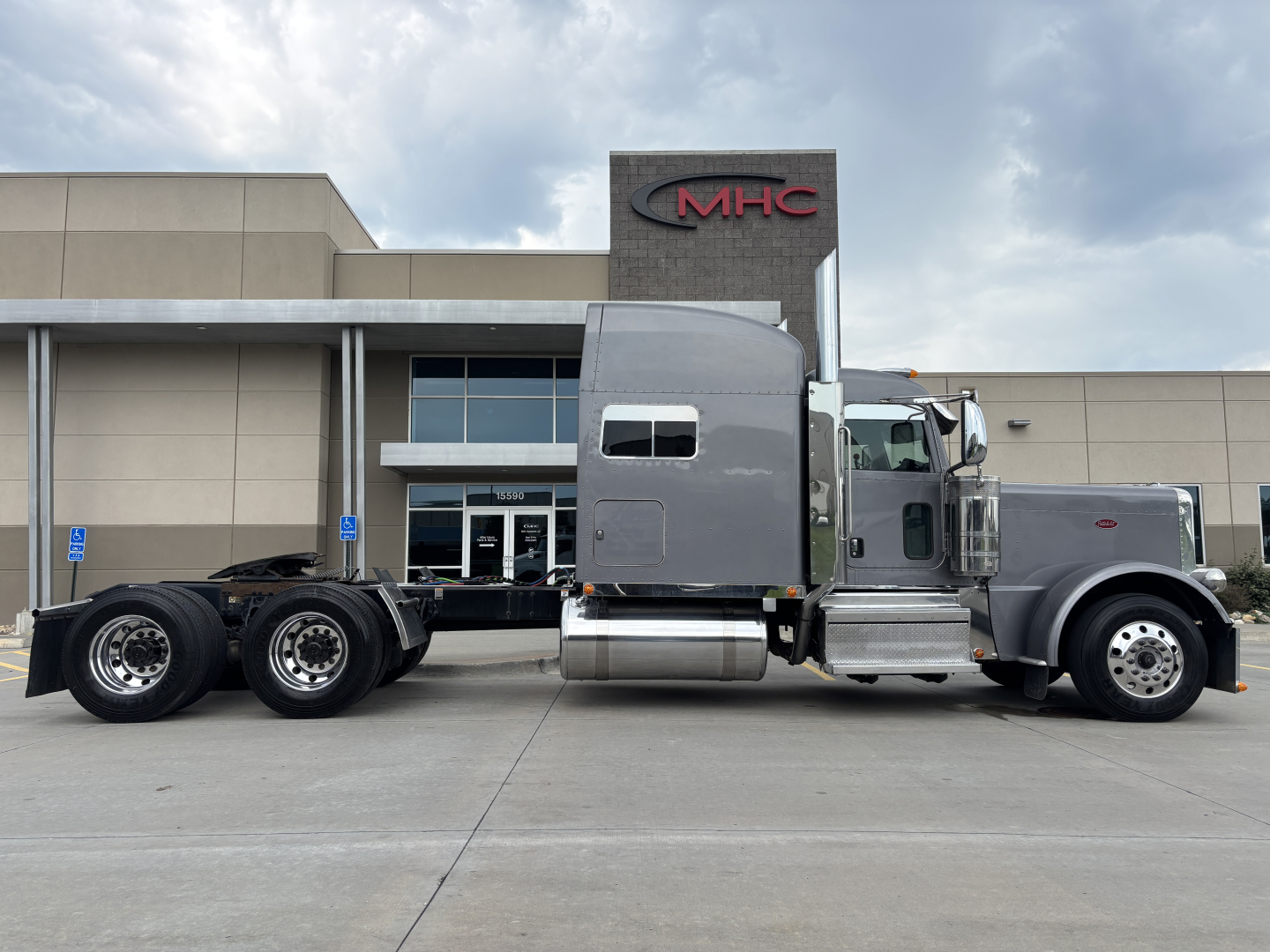 Peterbilt 389 truck side view showing tractor cab and dual rear axles in the parking lot.