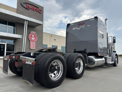 Peterbilt 389 tractor in view showing sleeper cab and dual rear axles with chrome fuel tanks and mud flaps