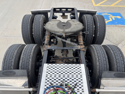 Peterbilt truck chassis with fifth wheel and dual rear-sets of wheels, view from above showing suspension and drivetrain components.