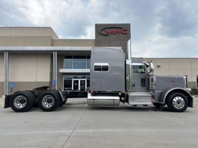 Peterbilt 389 truck side view showing tractor cab and dual rear axles in the parking lot.
