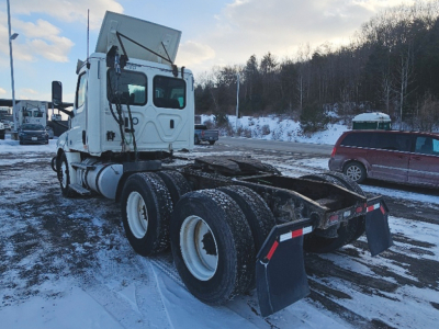 Truck chassis rear view of a 2019 Freightliner Cascadia126 with dual rear axles and mud flaps.