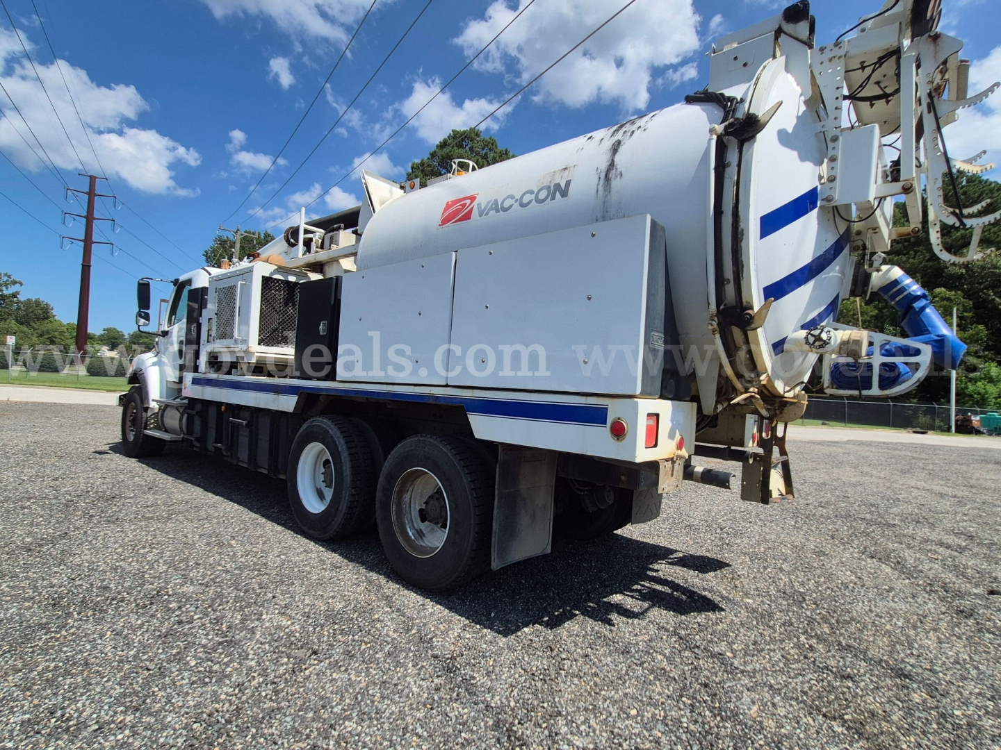 Freightliner M2 106V vacuum truck showcasing side tank and rear apparatus with Vaccon branding, three axles, white/blue color scheme.