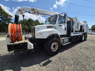 Freightliner M2 106V vacuum truck with large orange hose reel on front bumper and long hose reel on a white cab chassis