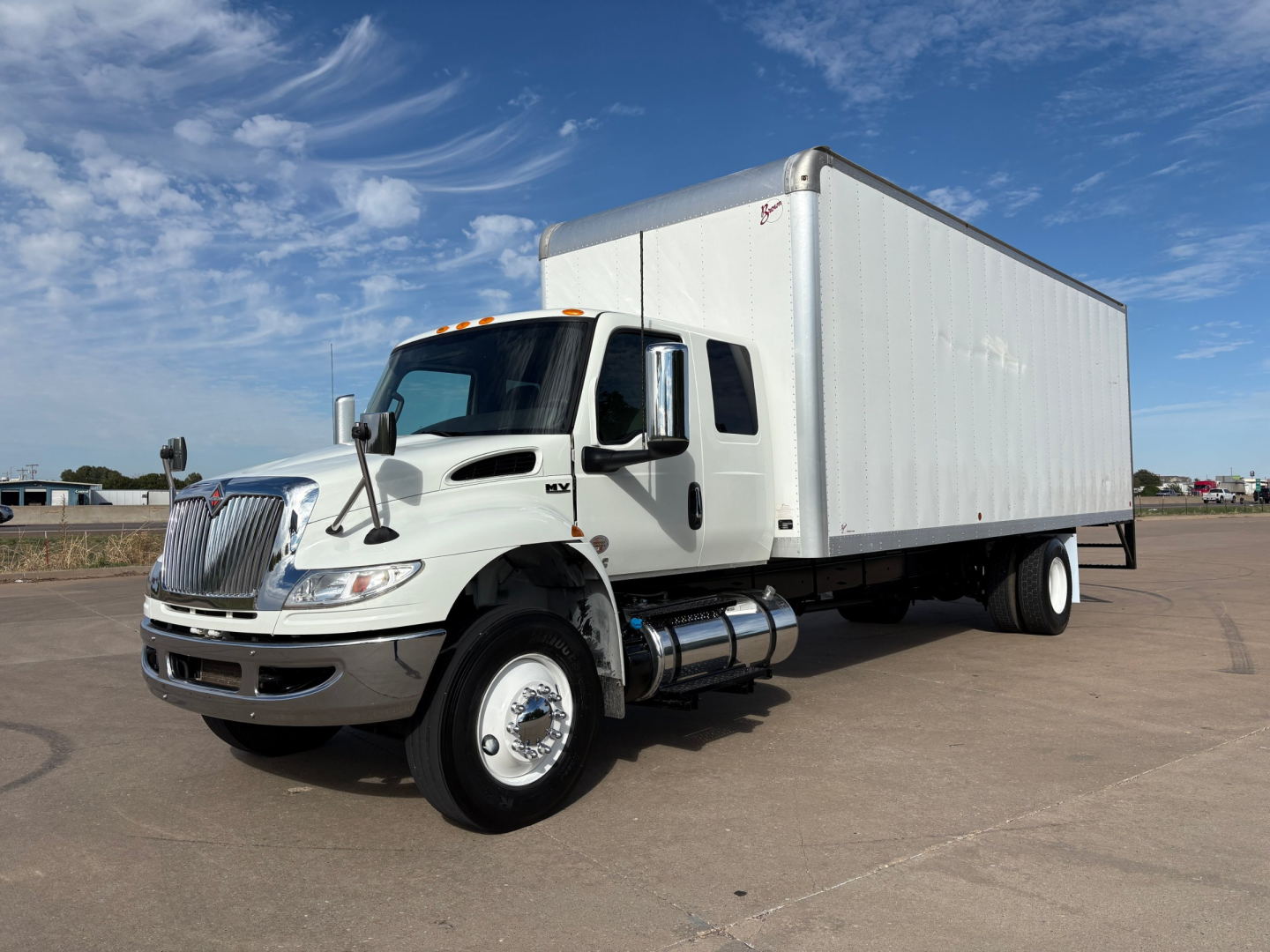 Truck in service bay showing 2020 International MV607 box truck with white cab and cargo box, side view, VIN 3HAEUMML8LL865999 visible.