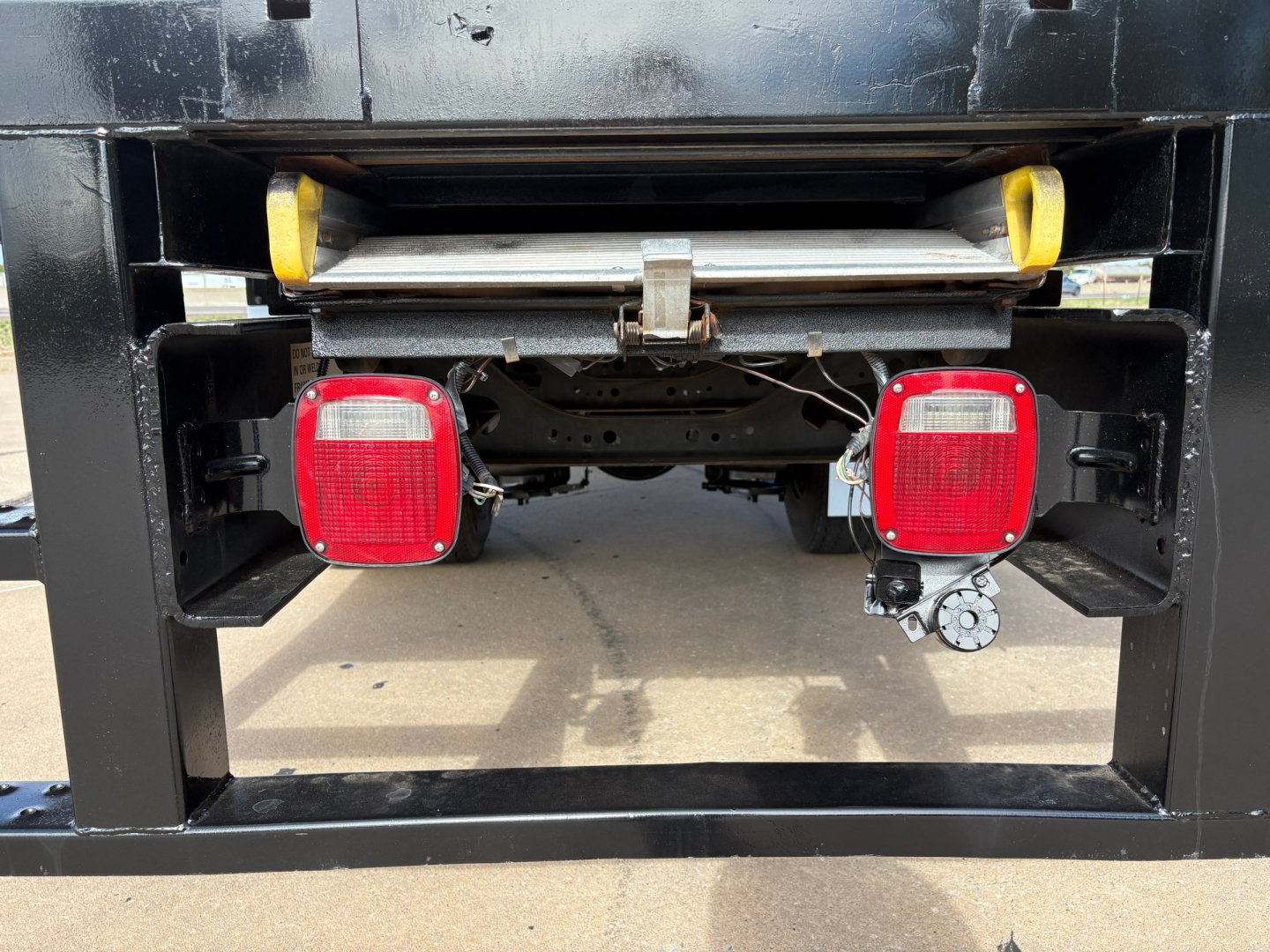 Rear view of a 2020 International MV607 truck showing taillights, bumper, and spare wheel carrier in a black chassis.