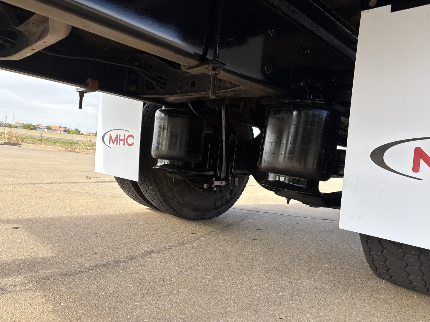 Underbody of a box truck showing dual air tanks and rear wheels; no legible model text visible.