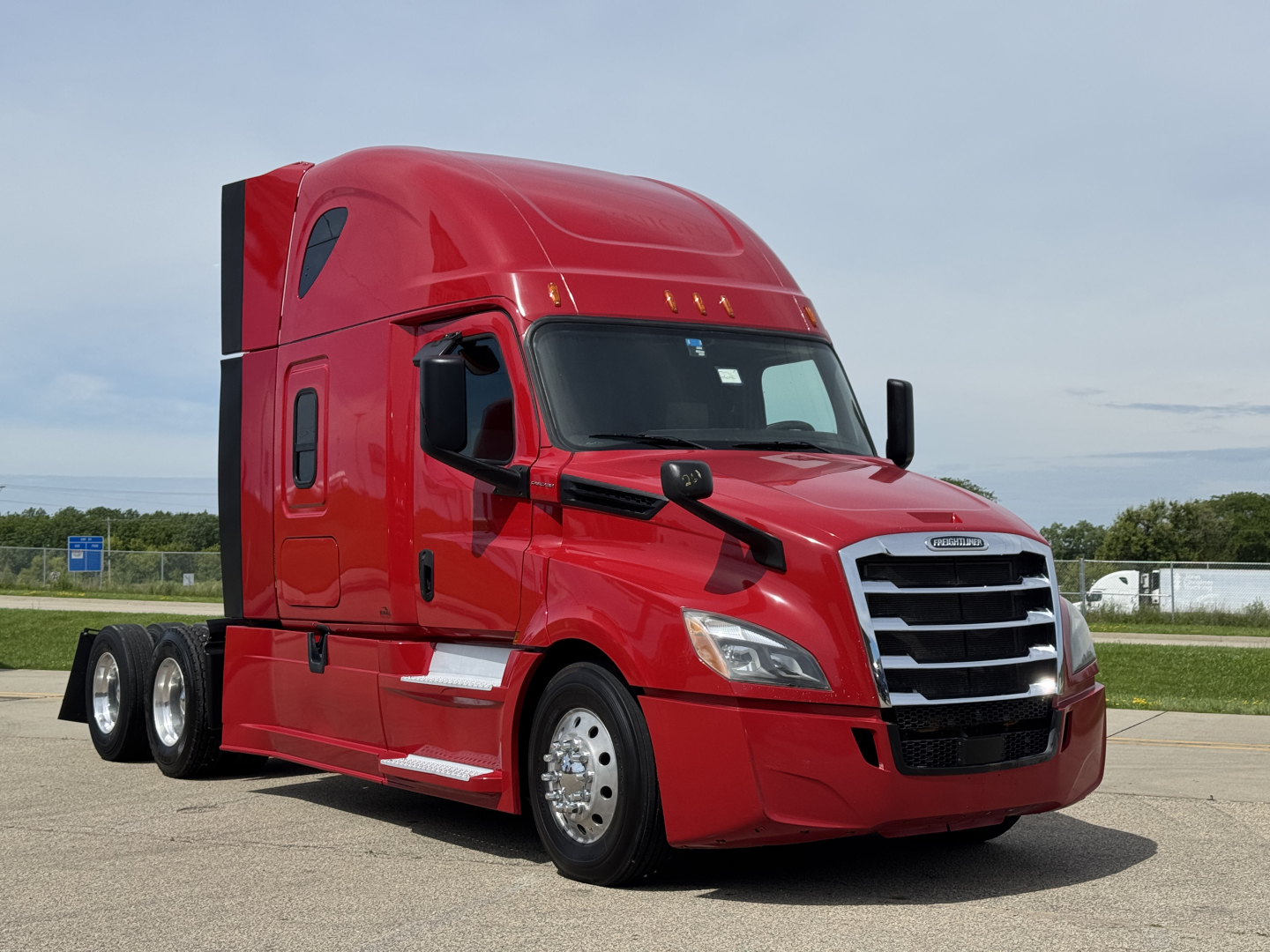Truck engine bay not visible; red Freightliner Cascadia 126 sleeper tractor front-left view.