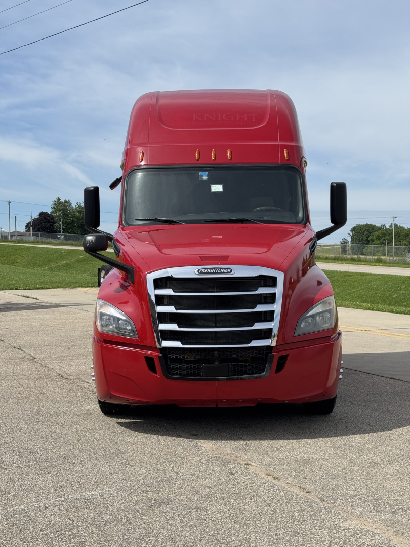 Freightliner Cascadia 126 cab front view showing bold chrome grille, headlights, and red exterior.