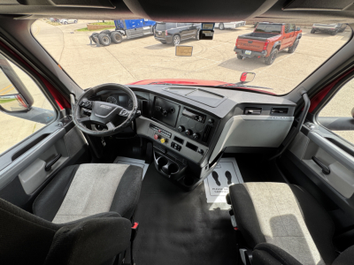 Conventional sleeper truck cab interior showing steering wheel, dashboard, and center console of a 2019 Freightliner Cascadia 126.