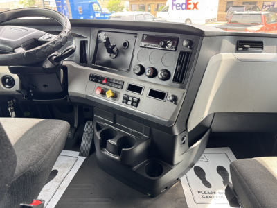 Dashboard of a 2019 Freightliner Cascadia 126 sleeper cab showing steering wheel, control panel with gauges, vents, climate controls, cup holders, and storage compartments.