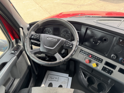 Freightliner Cascadia 126 interior showing steering wheel, dashboard, and center control panel.