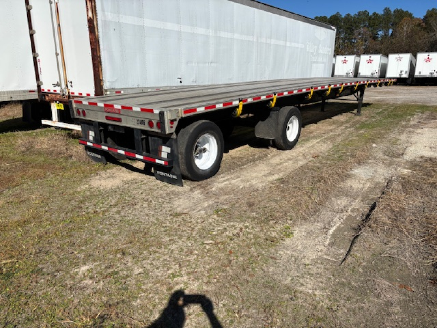 Flatbed trailer with dual rear axles and extension rail, Fontaine Infinity branding not visible on trailer; image shows the back and side of a 2022 Fontaine Infinity flatbed expandable trailer.
