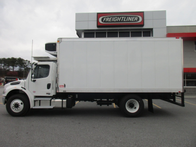 Freightliner M2 106 Plus refrigerated box truck side view in front of dealership with Freightliner signage.