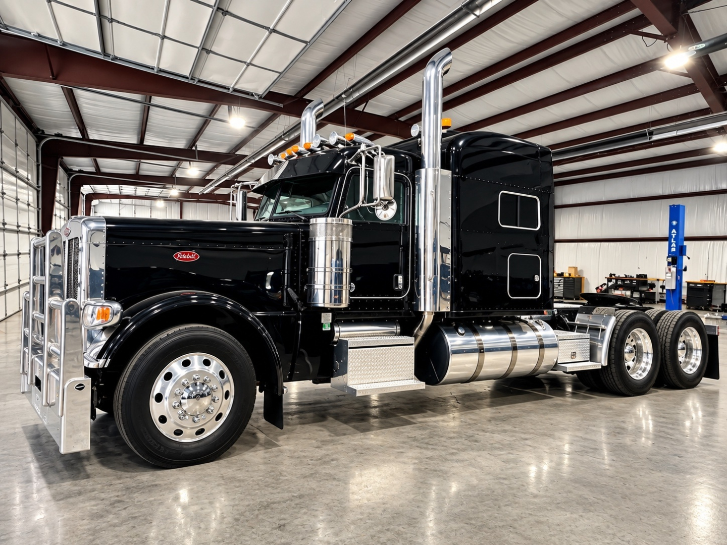 Peterbilt 389 conventional sleeper truck in a showroom with black paint, chrome accents, dual stacks, and polished fuel tanks.