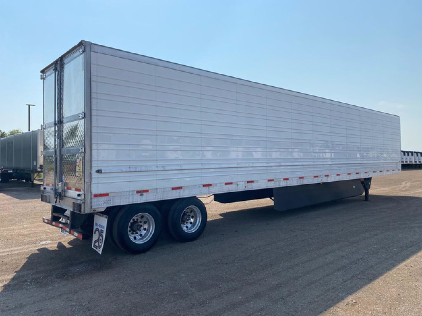 Trailer side view showing a 2021 Utility reefer trailer with silver exterior and dual rear wheels, stock U91109.