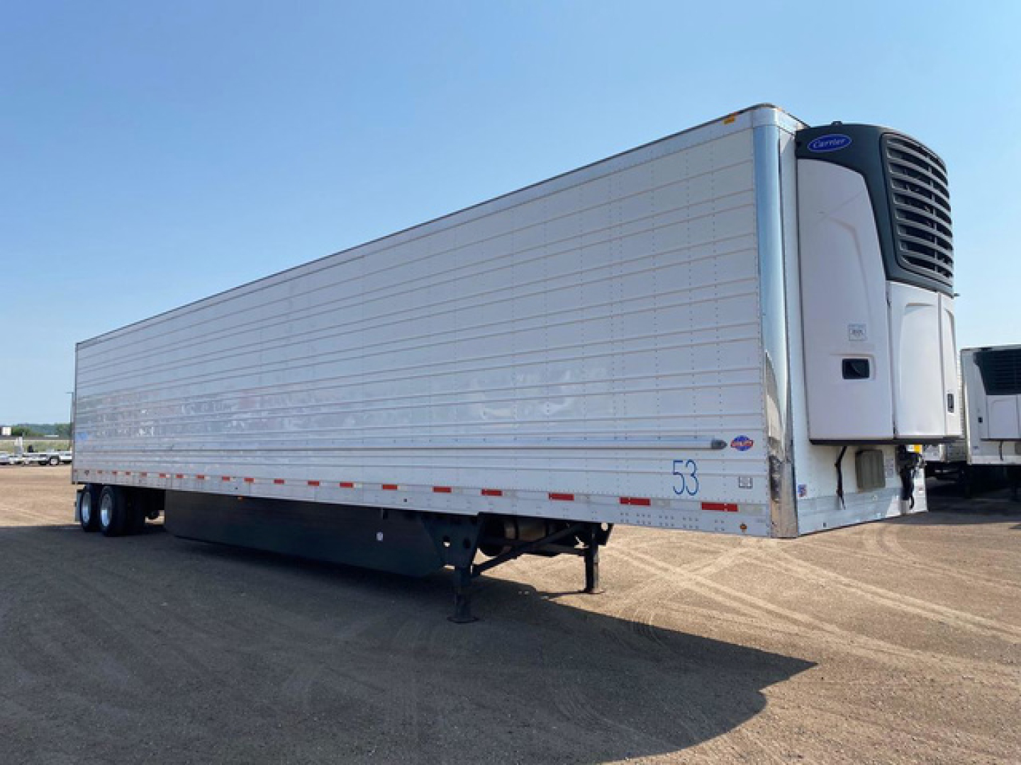 Trailer side view showing refrigerated utility reefer with white aluminum body and front cooling unit.