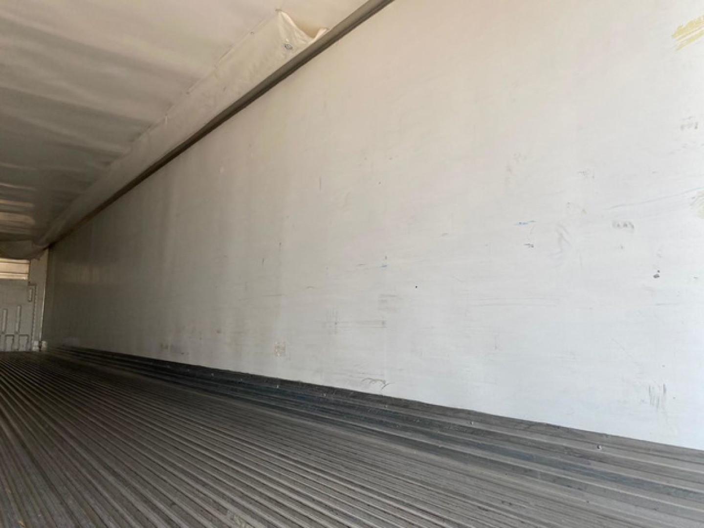 Trailer interior showing aluminum walls and ribbed floor of 2021 Utility Reefer trailer, cargo area empty, side walls smooth.