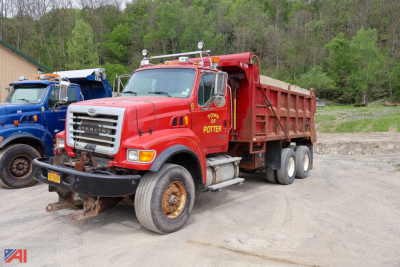 Red Sterling LT9500 dump truck showing company name 'TONY OF POTTER' on door; front grille, headlights, and dump bed visible; other blue truck in background.