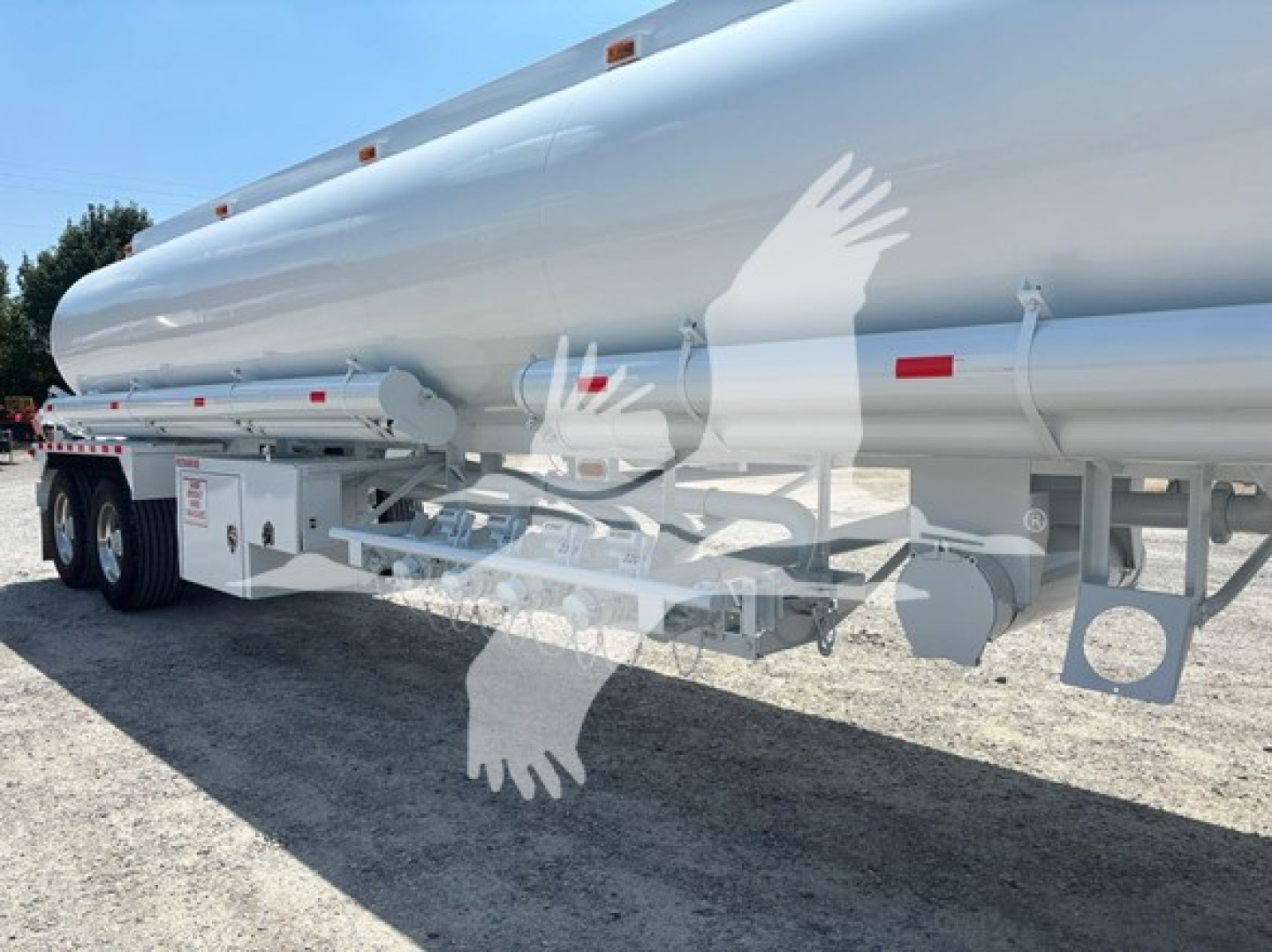 Fuel trailer side view showing large cylindrical tank with undercarriage, wheels, and support frame.