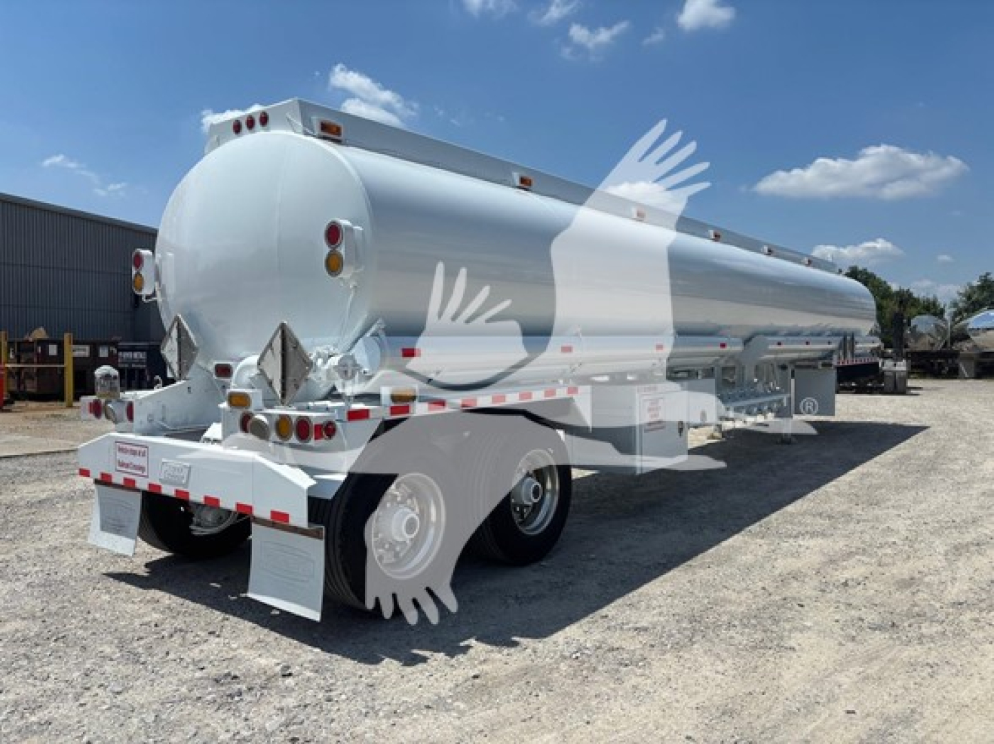 Tank trailer showing rounded cylindrical steel tank on dual-axle chassis with rear plug and ladder, label decals, and reflective safety markings.