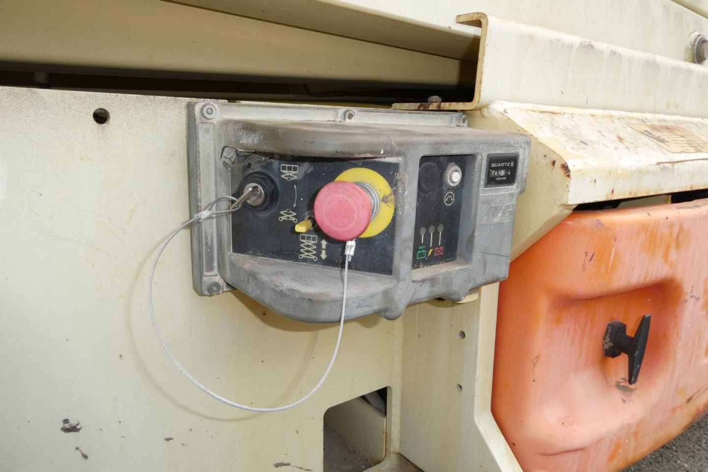 JLG 2646ES scissor lift control panel with red emergency stop button and circular key/knob visible.