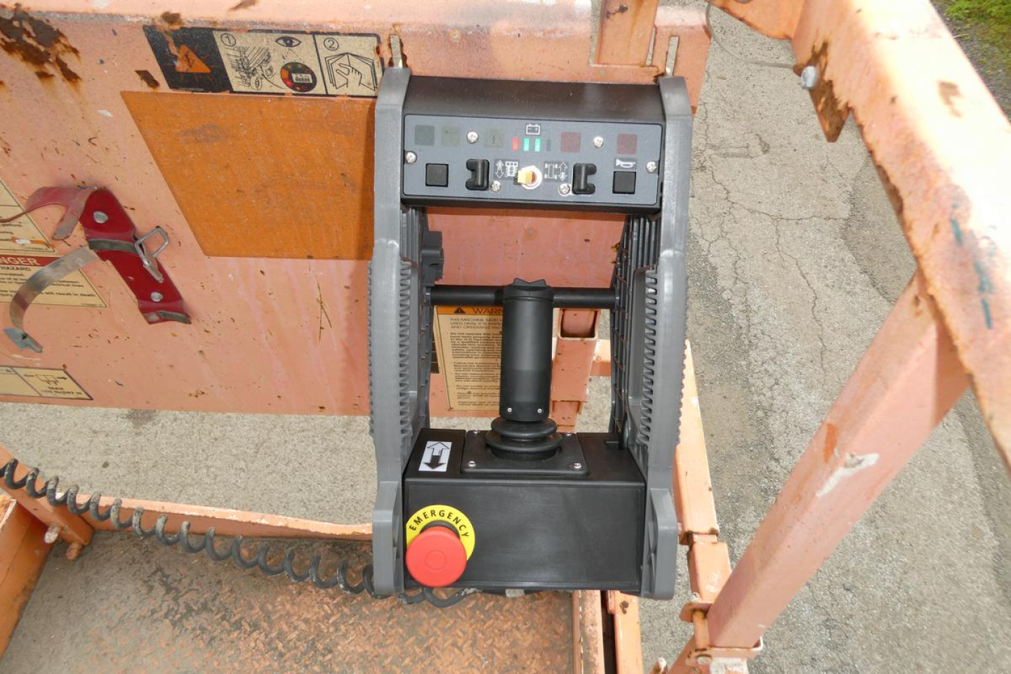 Control panel and joystick on a JLG 2646ES scissor lift with control box and emergency stop button visible.