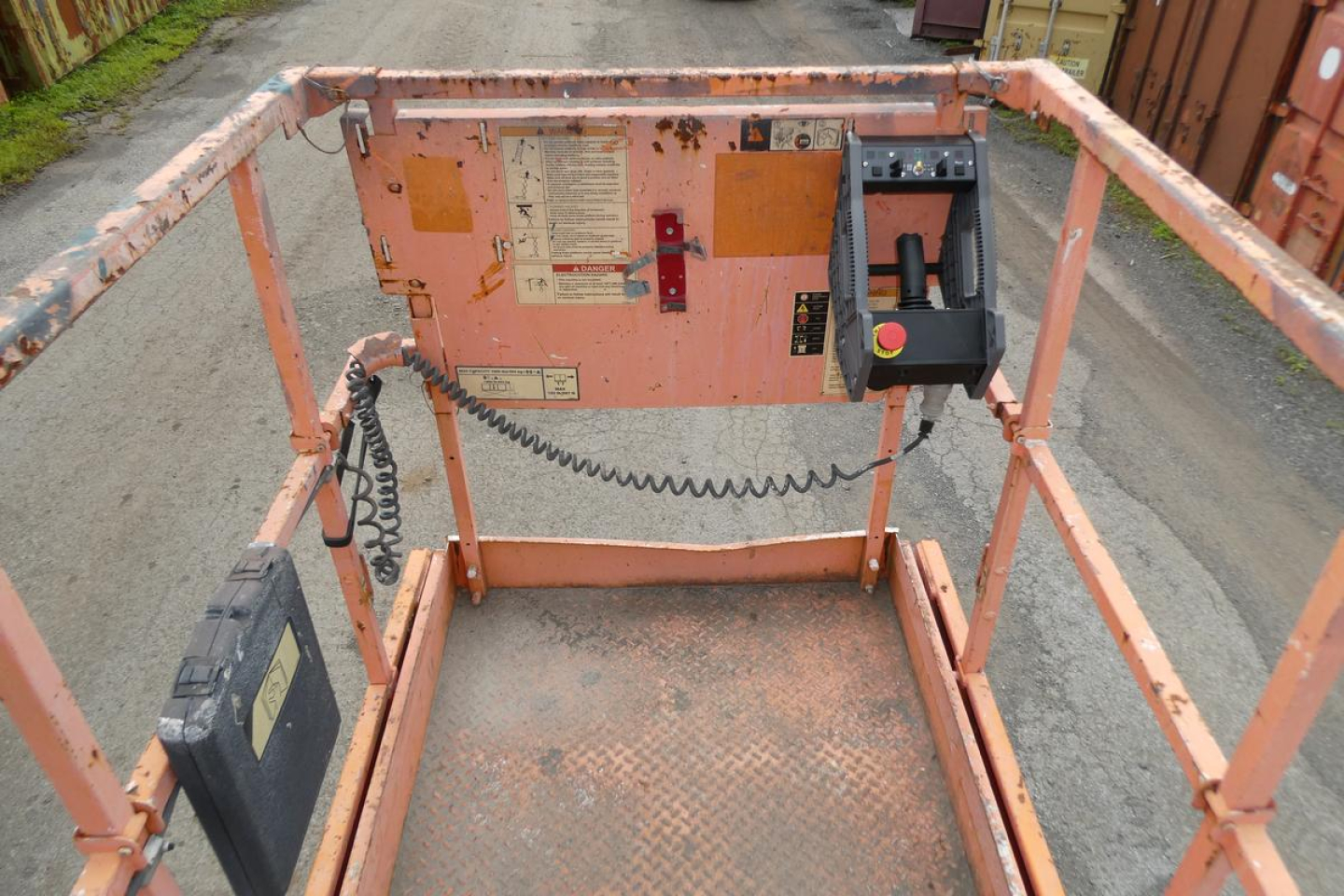 JLG 2646ES scissor lift control panel and platform edge with labels and control switches visible.